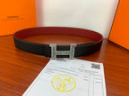 Hermes belt flat view: black textured leather with silver-tone H buckle, red lining