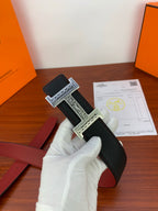 Hermes belt, black textured strap with ornate silver H buckle, red lining detail