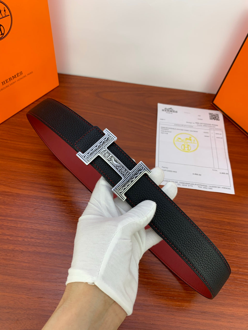 Hermes belt in black textured leather with silver-tone H buckle and red underside