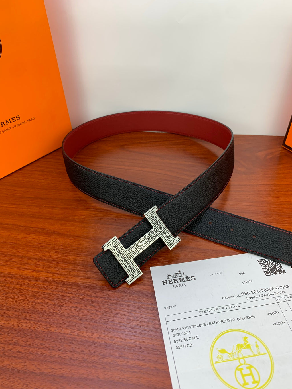 Hermes belt laid flat: black textured leather strap with silver H buckle