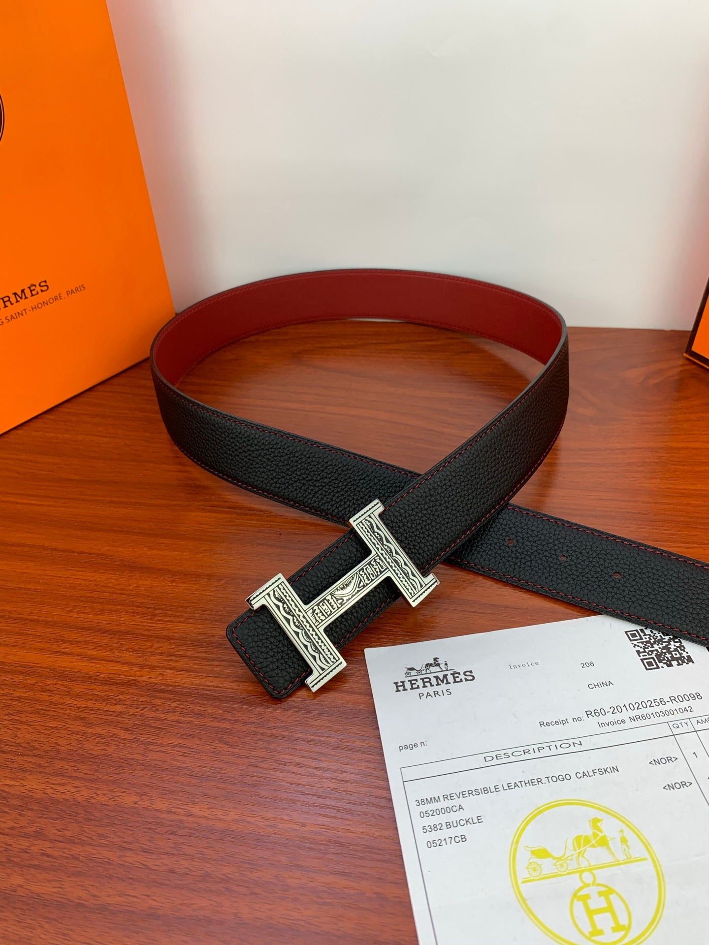 Hermes belt laid flat: black textured leather strap with silver H buckle