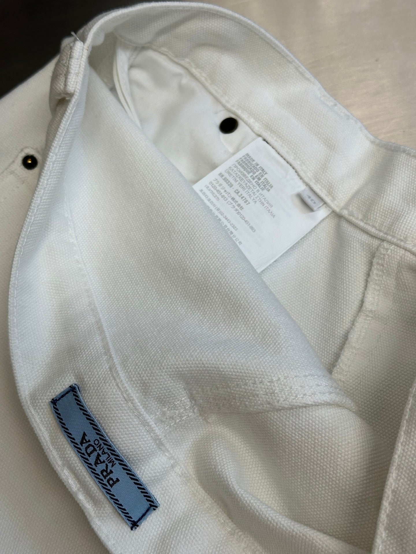Off-white cargo pants interior with white care label and stitched trim