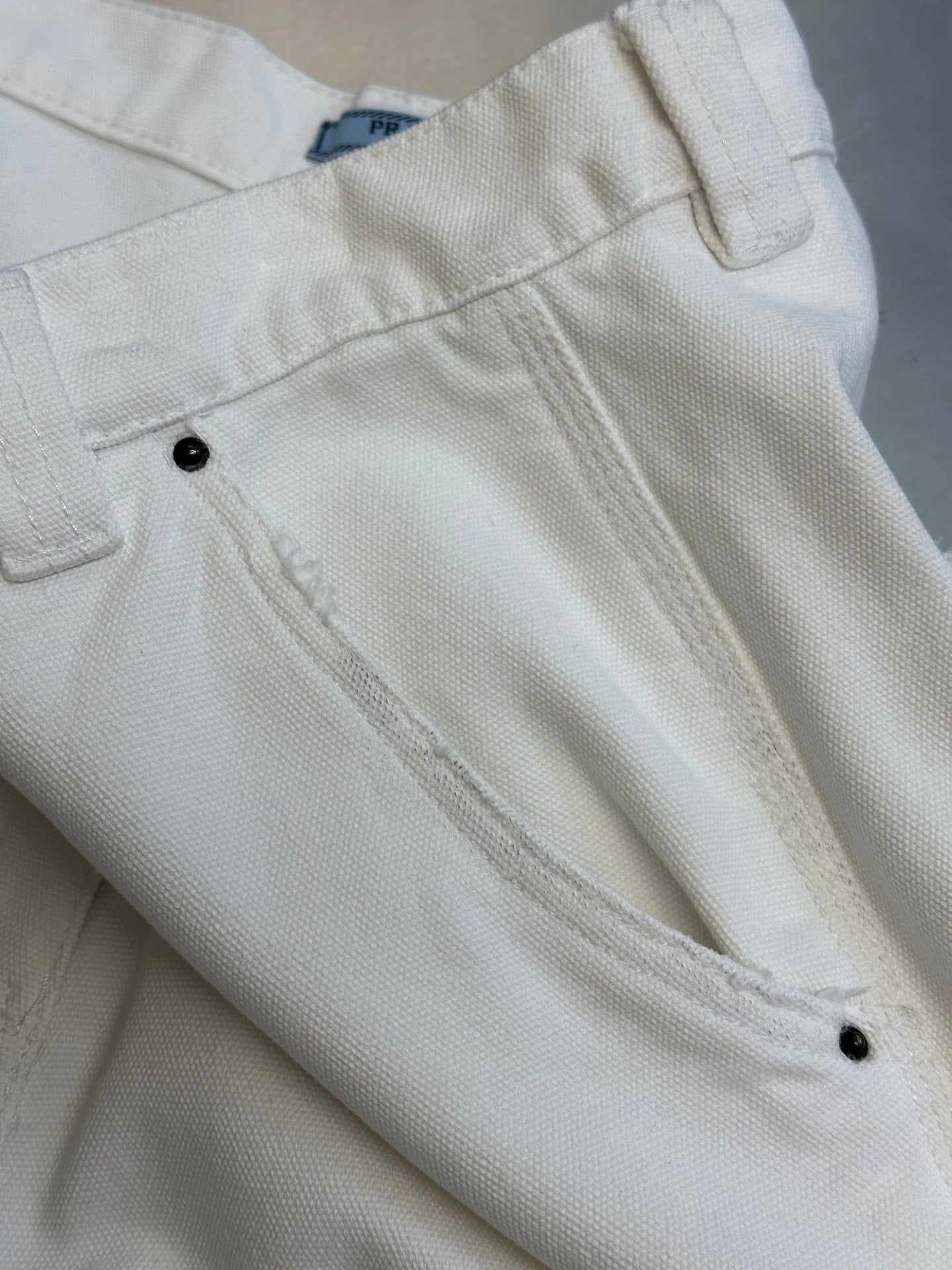 Prada off-white cargo pants with front patch pockets and angled stitched seams