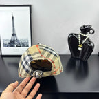 Burberry plaid baseball cap with beige, black, and red check pattern, adjustable strap.