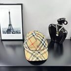 Burberry baseball cap in beige, black, and red plaid with curved brim and emblem front.