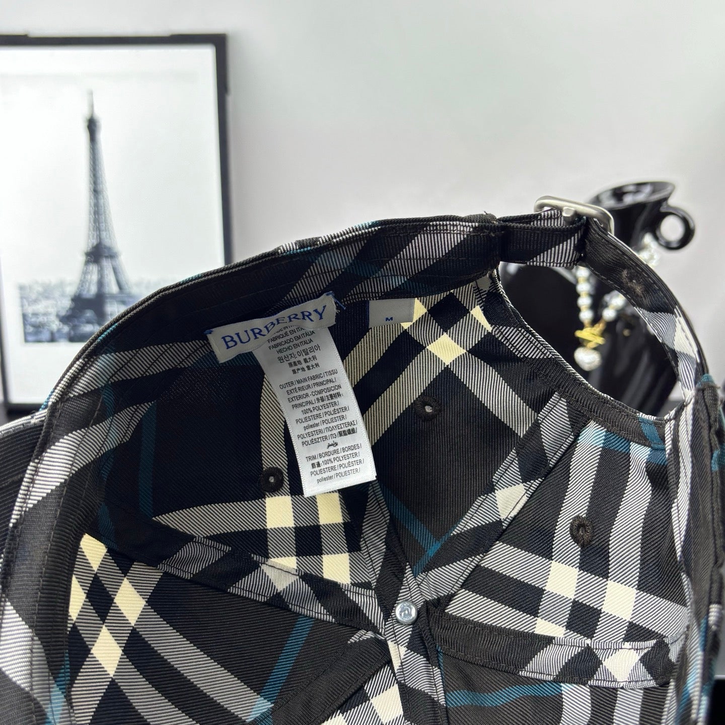 Burberry cap interior with woven label and dark/white plaid lining.