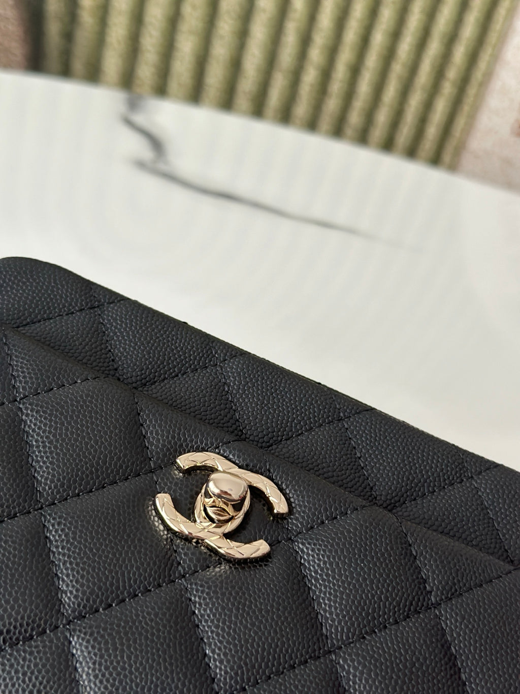Chanel bag logo detail, black quilted leather with gold-tone CC emblem