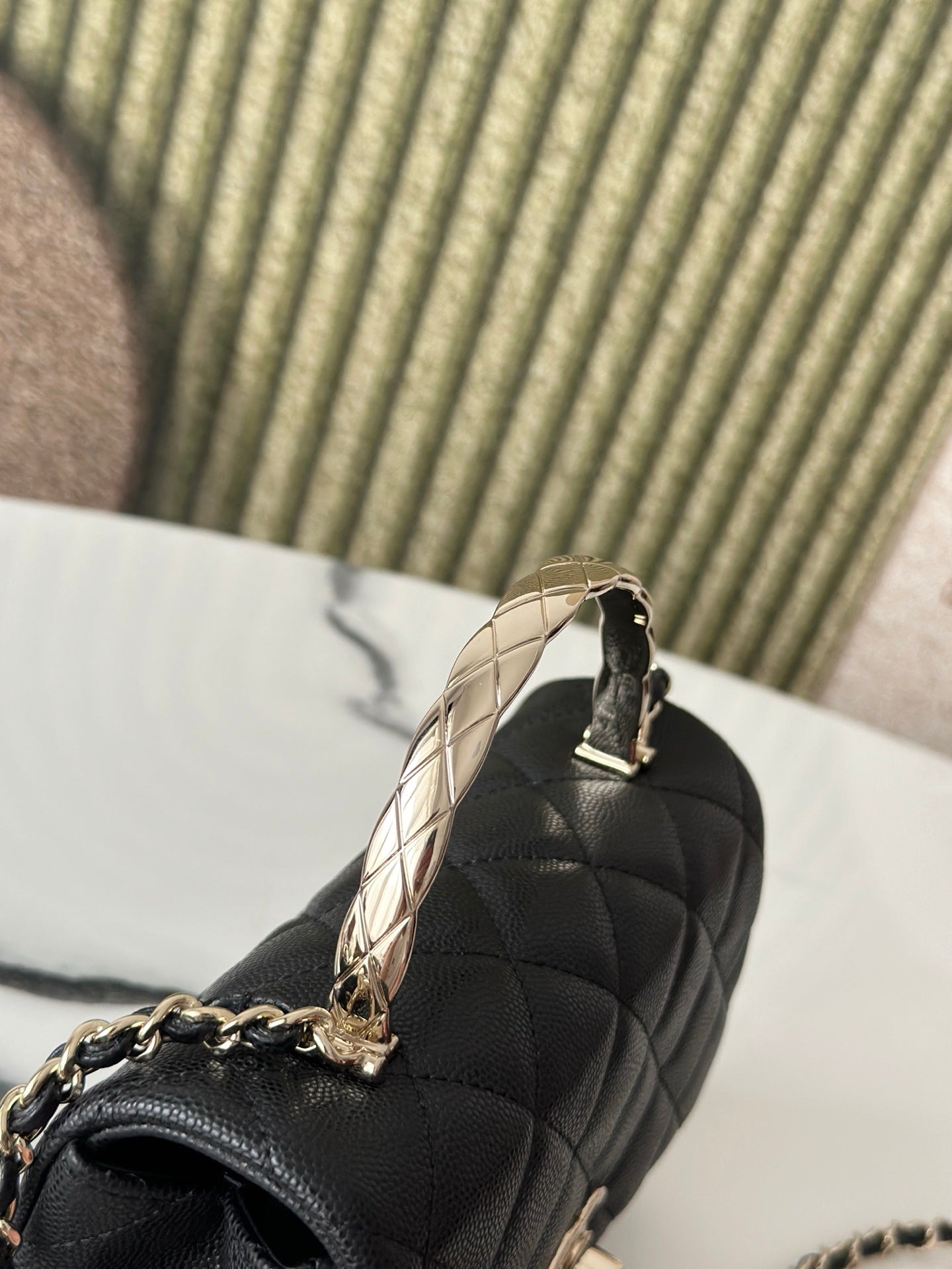 Chanel bag top view, black quilted leather with gold-tone chain