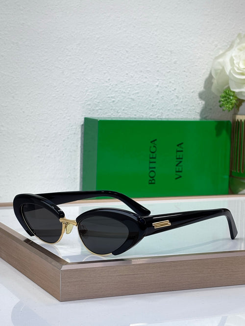 Bottega Veneta sunglasses with black frames, oval dark lenses, and gold accents
