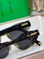 Bottega Veneta sunglasses close-up with black frames and gold hinge detail