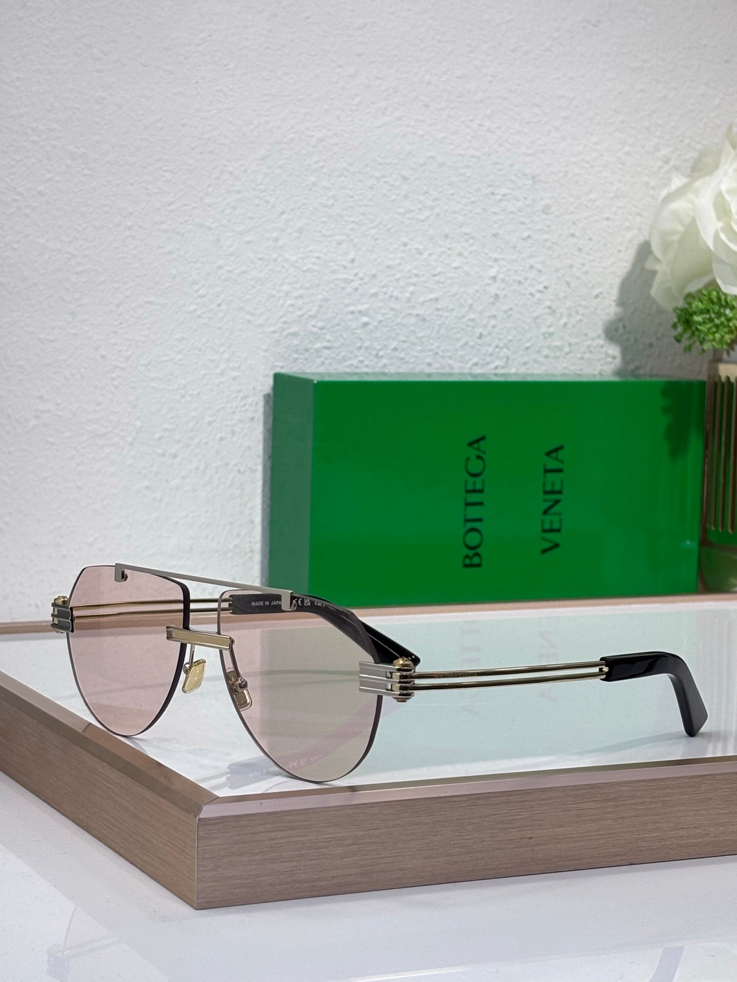 Sunglasses with light gradient lenses and gold-tone metal frame, dark acetate temples