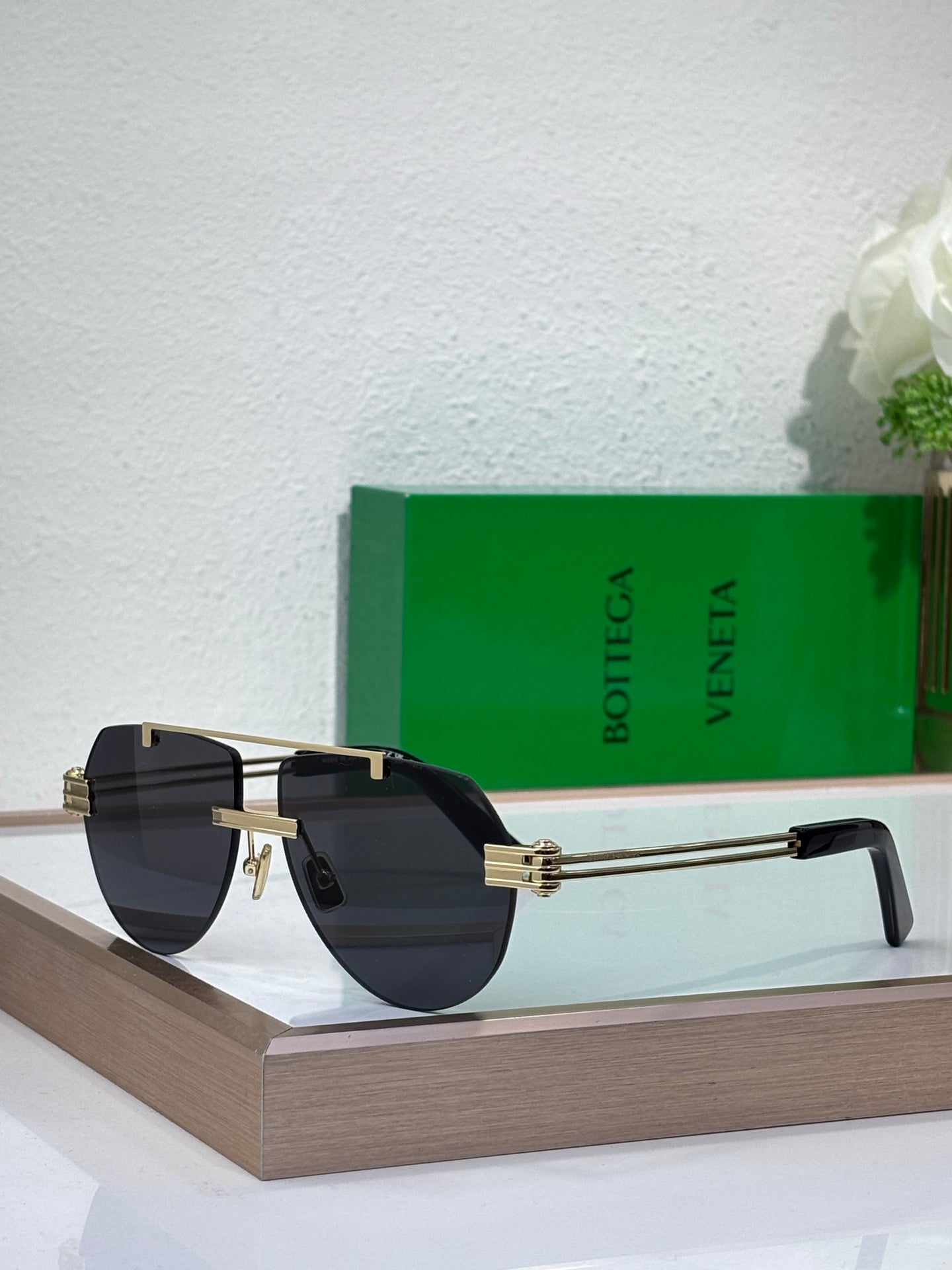 Sunglasses with dark blue gradient lenses and gold-tone metal frame, tortoise temples