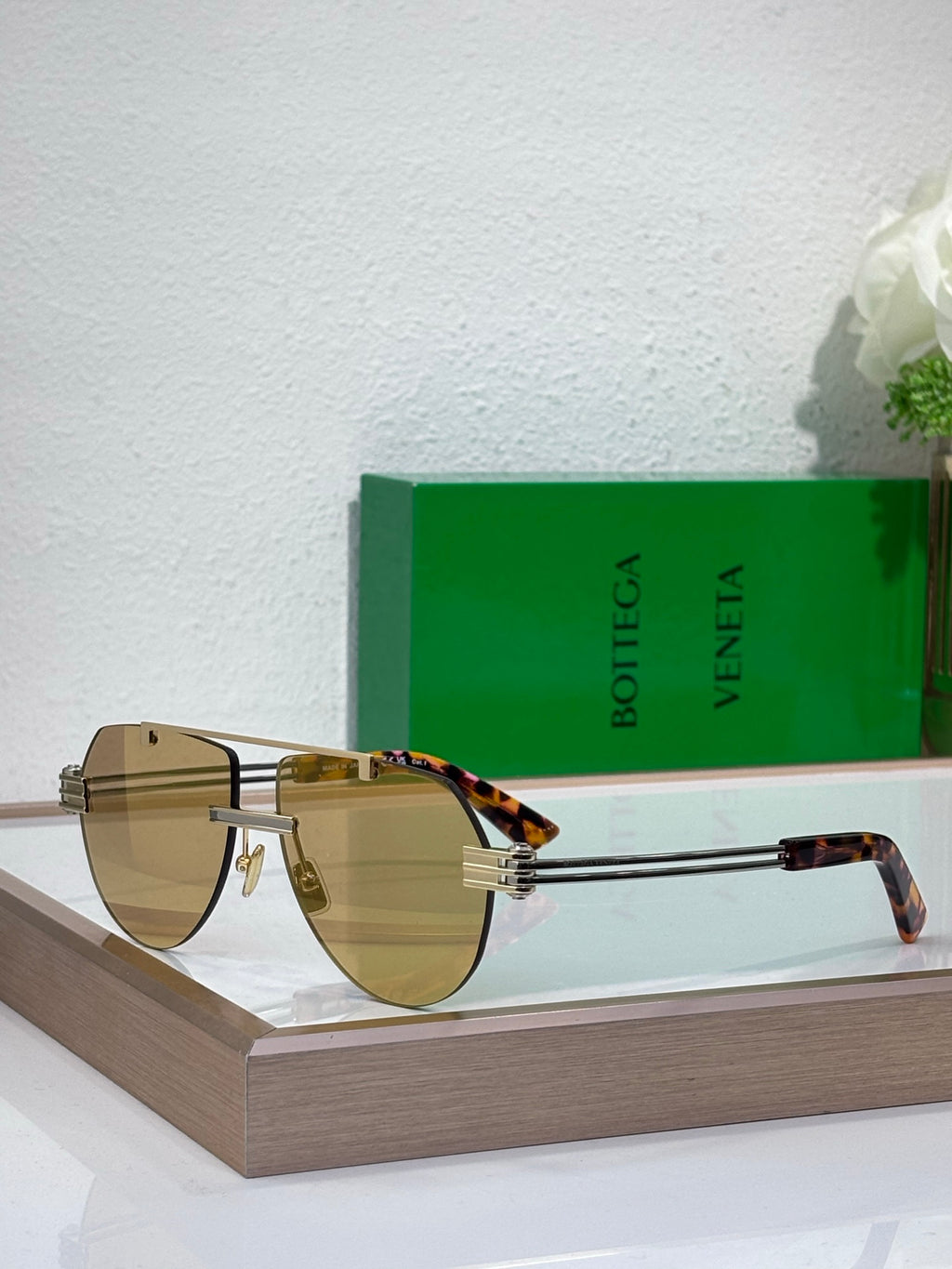Sunglasses with tan gradient lenses and gold-tone metal frame, tortoise temples