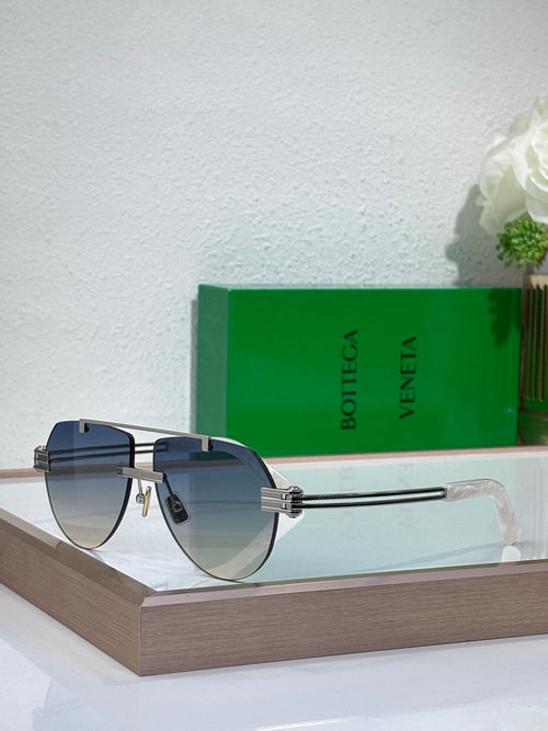 Sunglasses with dark lenses and gold-tone metal frame, tortoise-look side arms