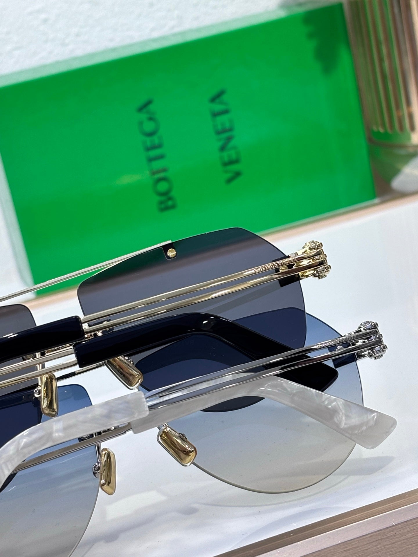 Sunglasses close-up with dark lenses and gold-tone metal hinges and side arms