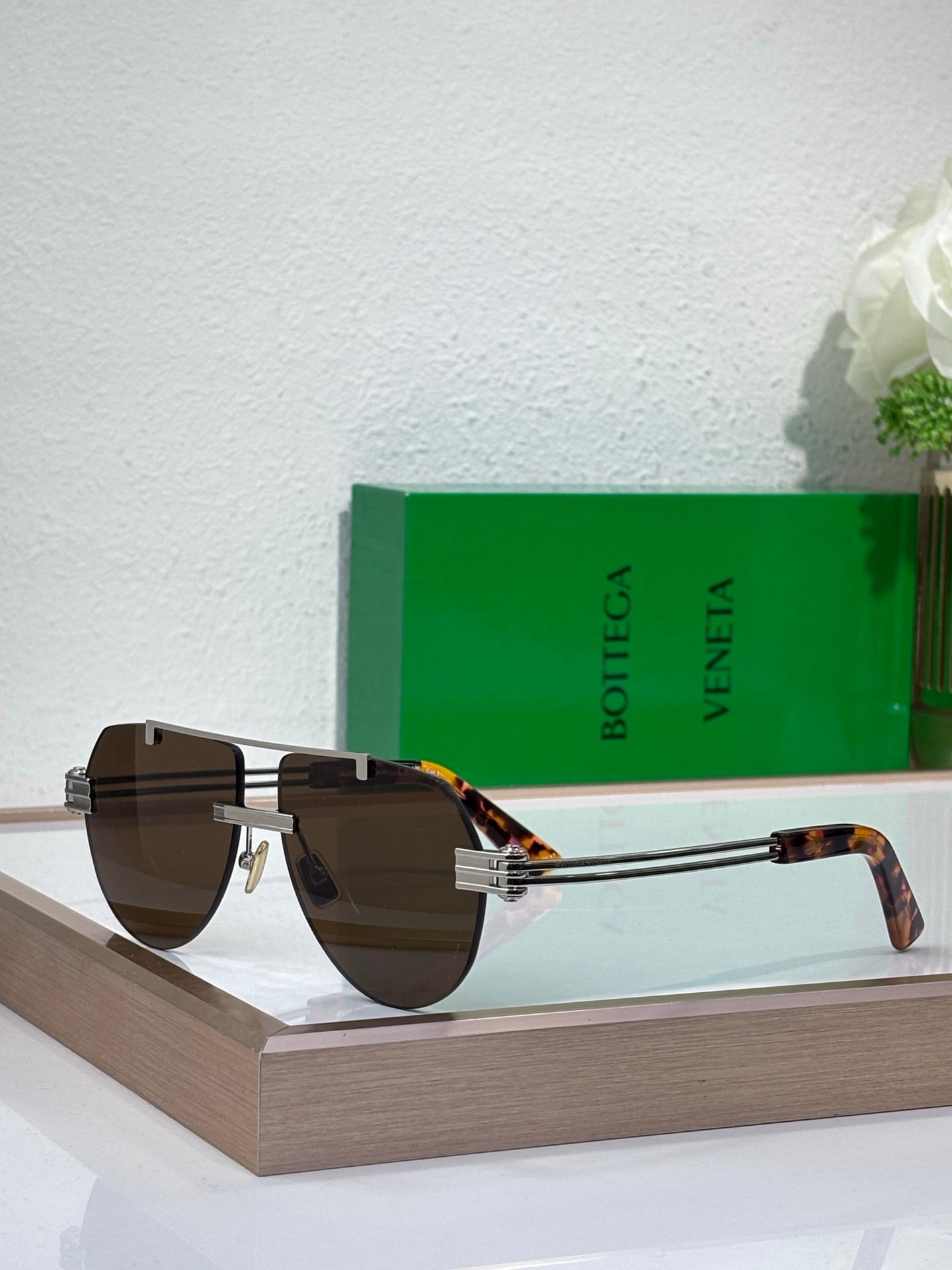 Sunglasses with brown gradient lenses and gold-tone metal frame, tortoise temples
