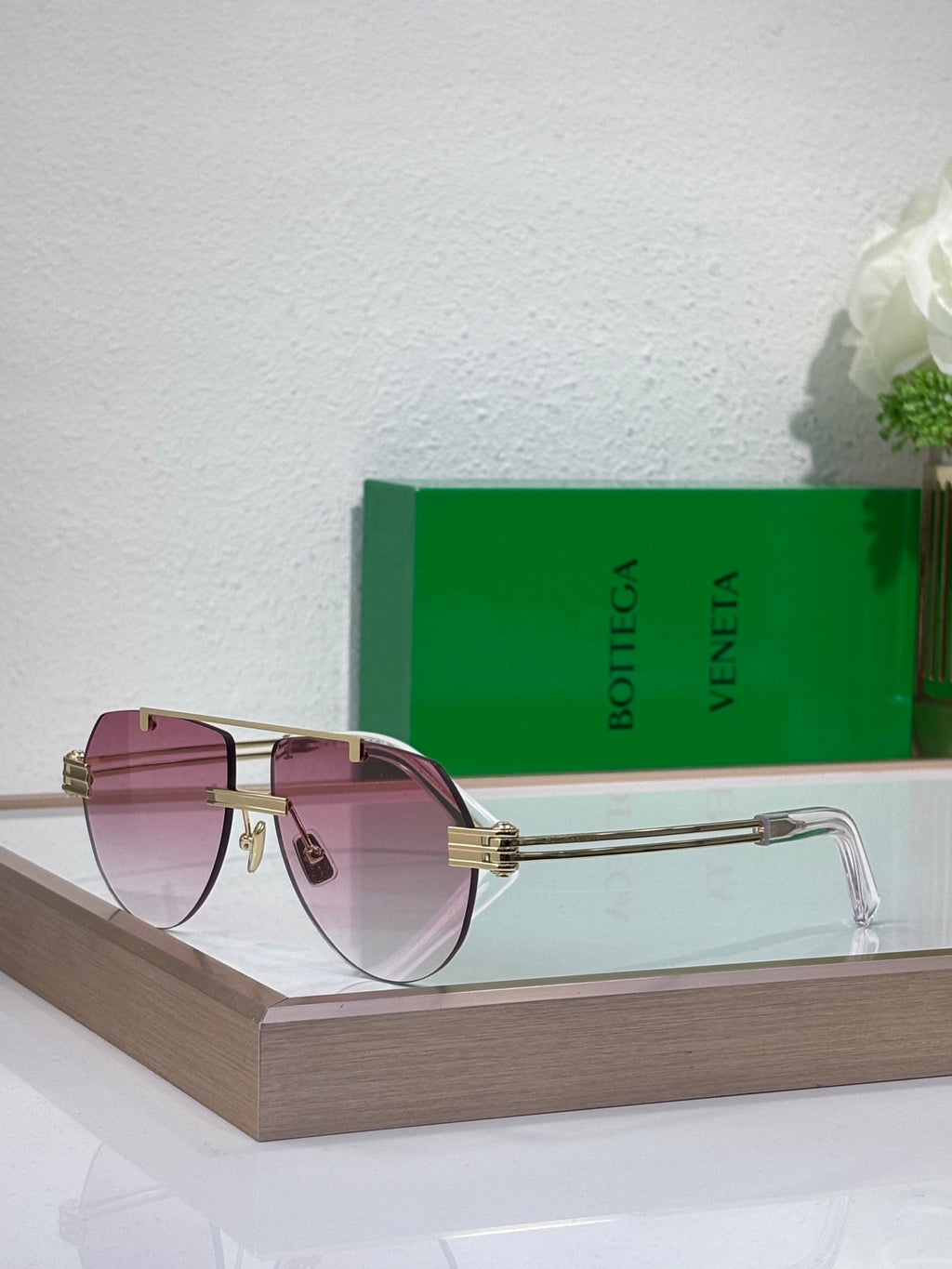 Sunglasses with pink gradient lenses and gold-tone metal frame, clear acetate temples