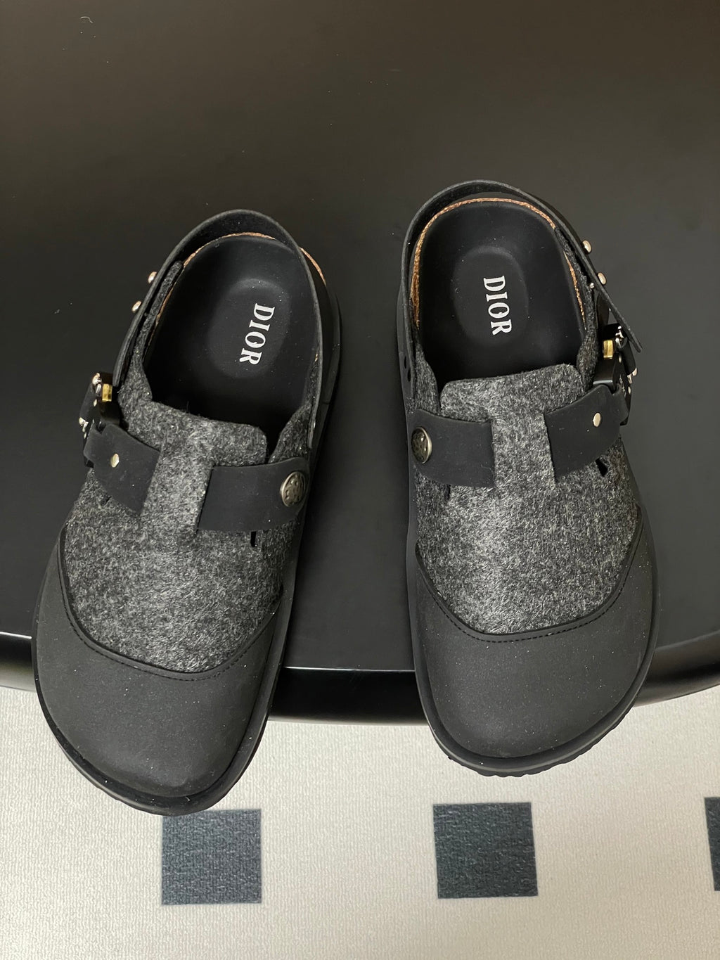 Dior sandals pair with DIOR logo on insole; gray textured top, black straps, gold studs