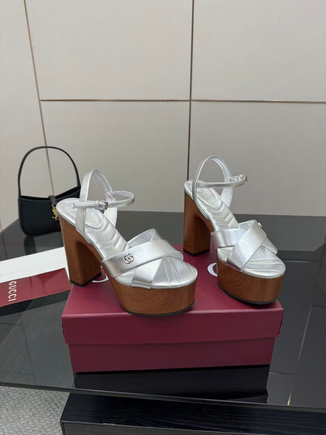 Gucci white heeled platform sandals with crisscross straps and black mini handbag