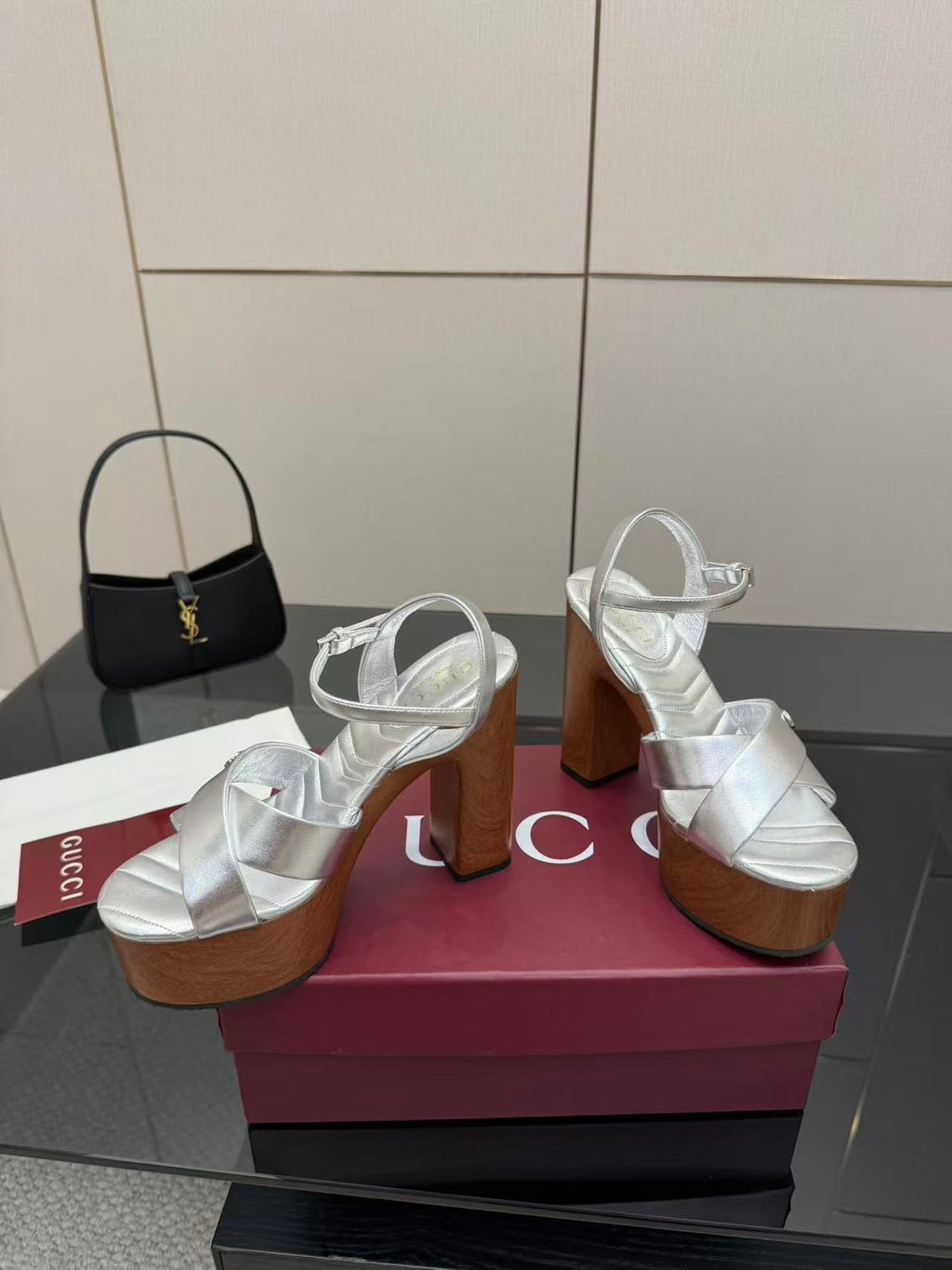 Gucci white platform heeled sandals with ankle-strap buckle and black mini handbag