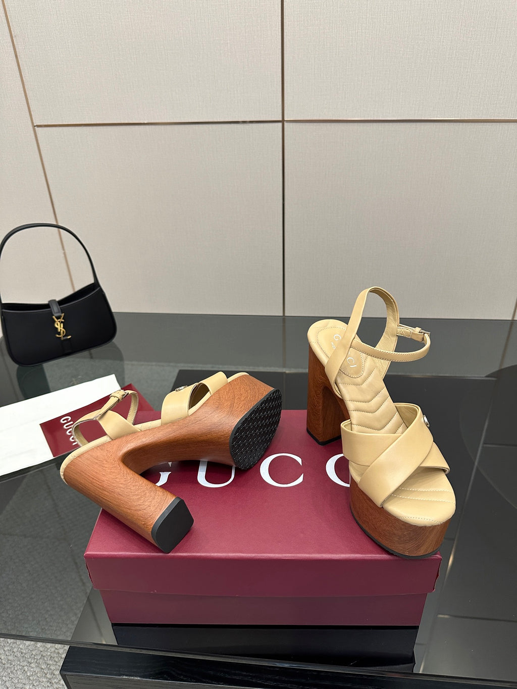 Gucci women's platform sandals display, cream pair with wood-tone heels plus a darker platform pair.