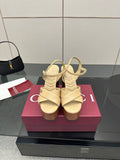 Gucci women's platform sandals, cream leather with crisscross straps and wood-tone heels.