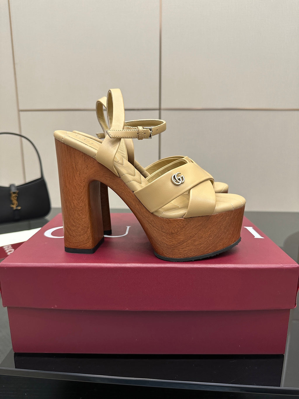 Gucci women's platform sandals, cream straps with open toe and thick wood-tone heels.