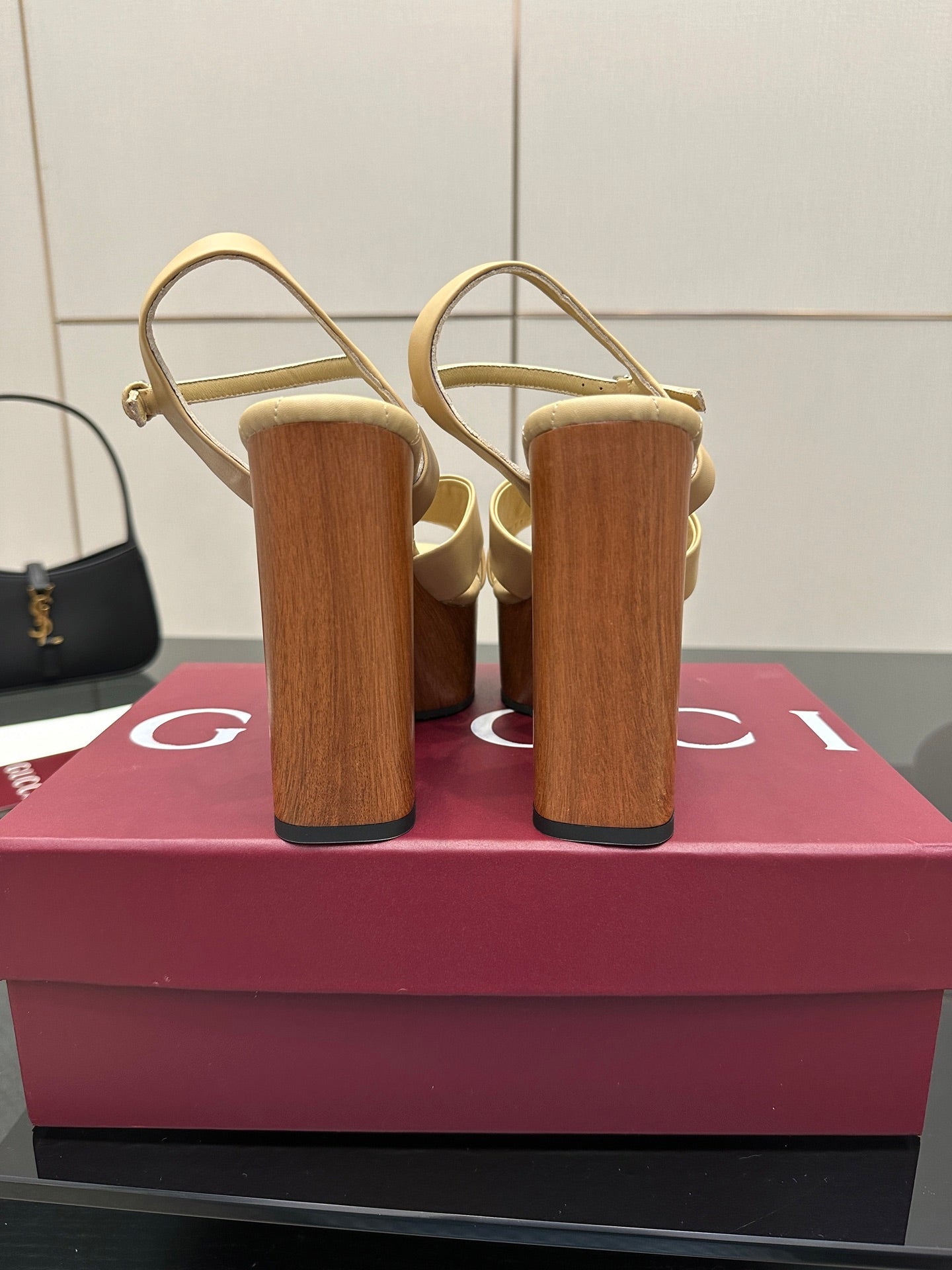 Gucci women's platform sandals, rear view with adjustable ankle strap and wood-tone heels.