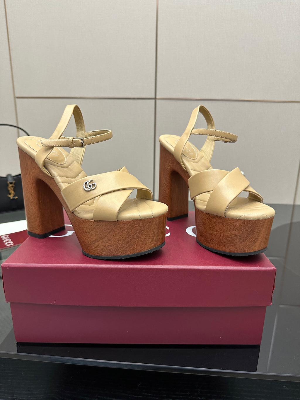 Gucci women's platform sandals, cream crisscross straps on chunky wood-tone block heels.