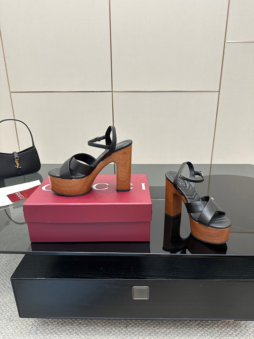Gucci black platform heeled sandals on display with wood-look platform and block heel
