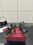 Gucci black platform heeled sandals, crisscross straps over a wood-look platform heel