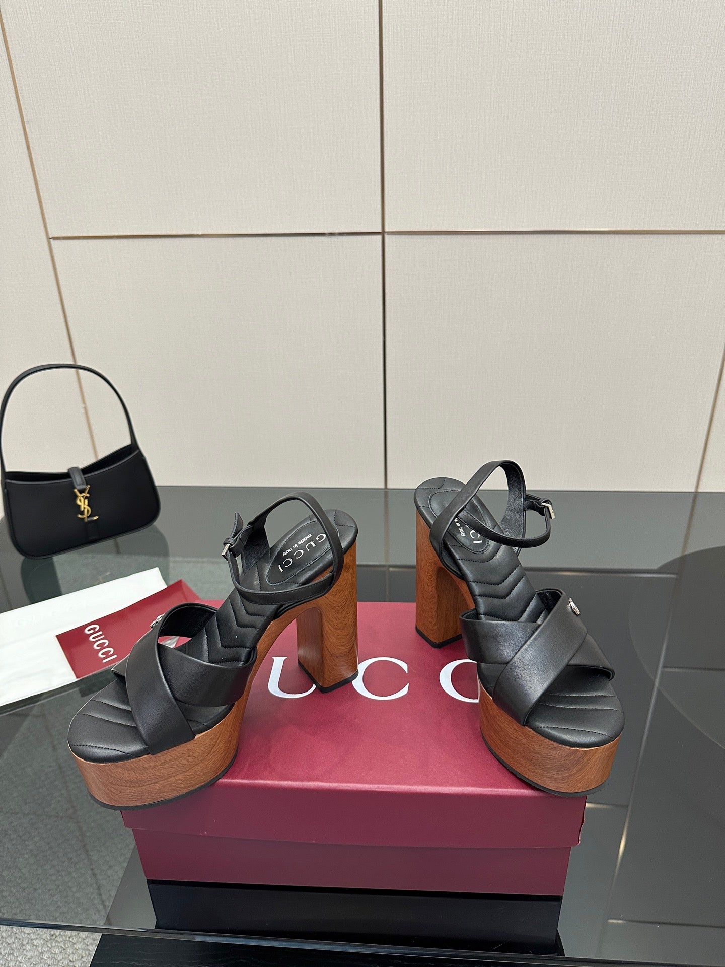 Gucci black platform heeled sandals, crisscross straps over a wood-look platform heel