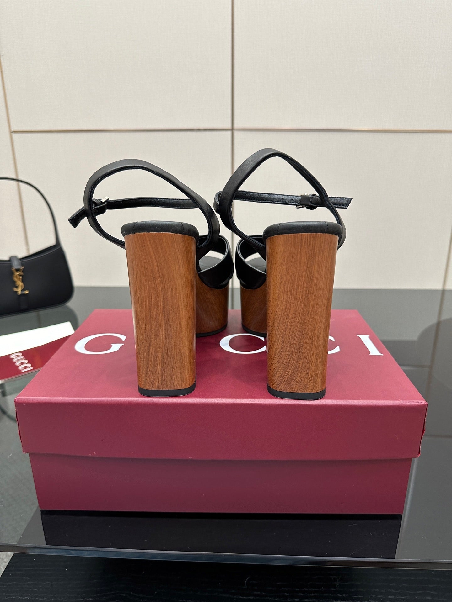 Gucci black platform heeled sandals, back view with ankle strap and wood-look heel