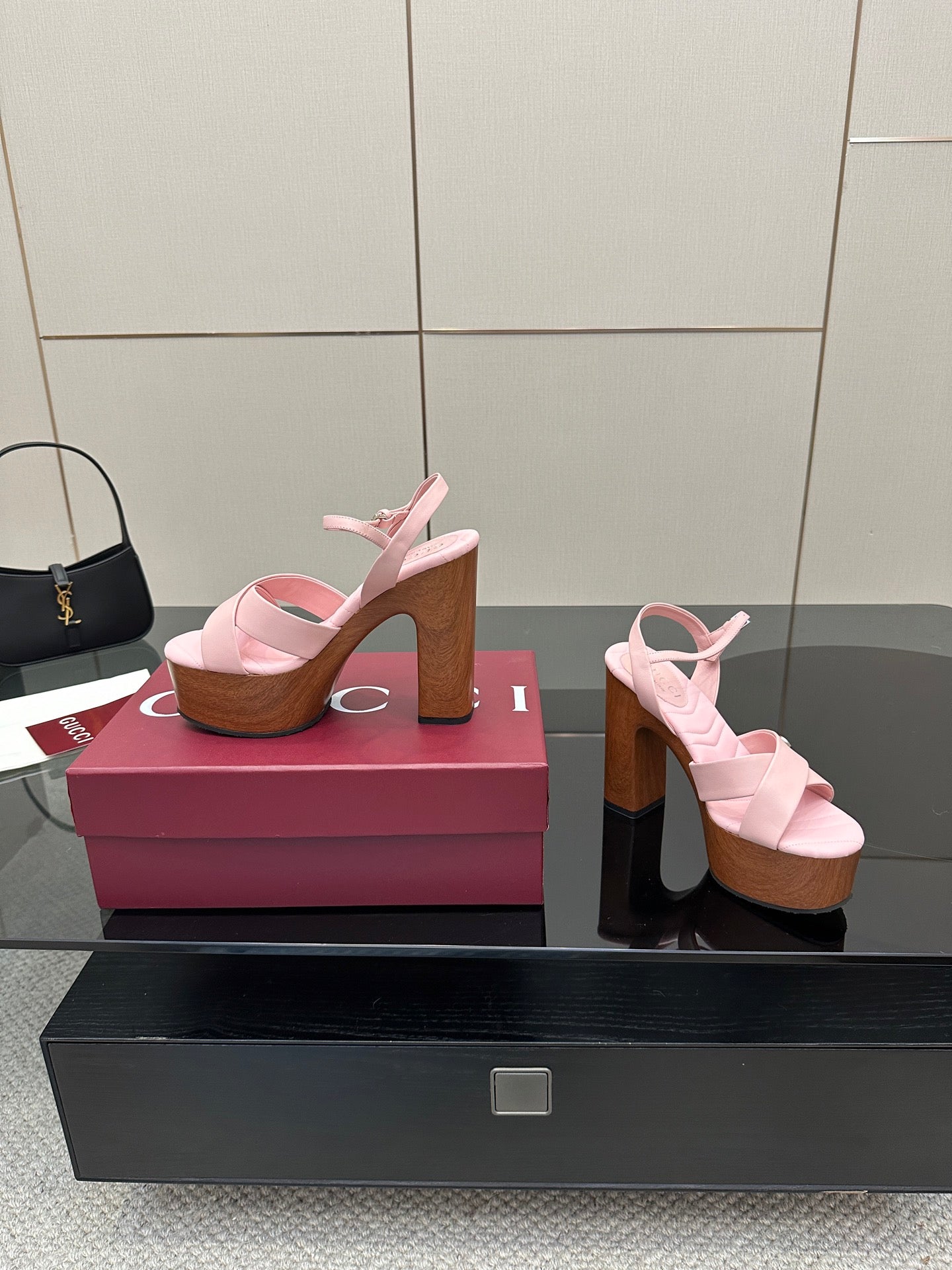 Pink platform sandals with thick straps and wooden heels, two views on a box