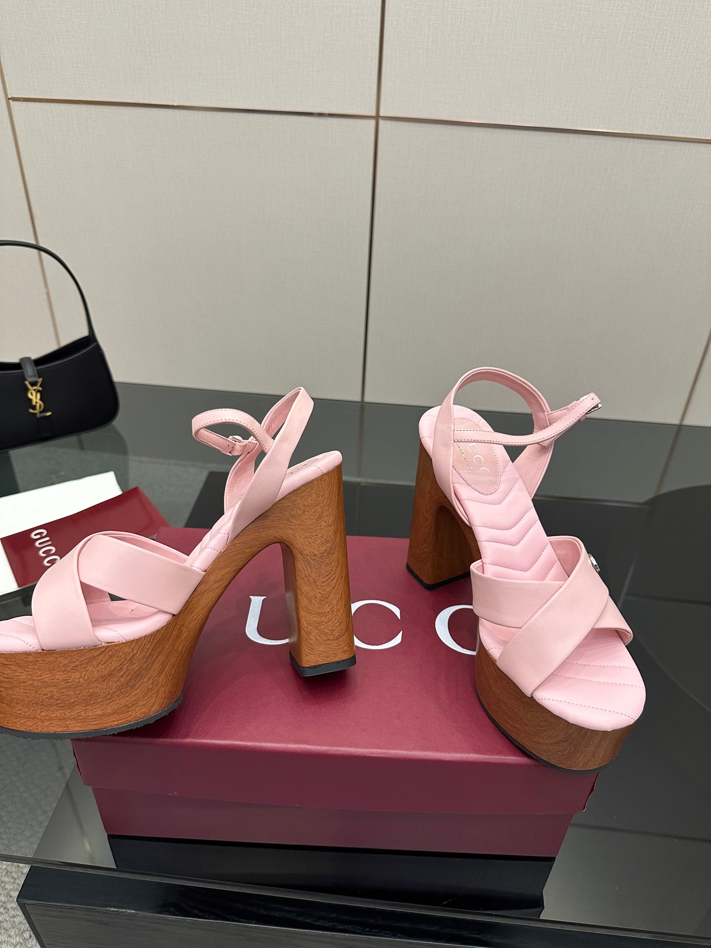 Pink platform sandals with wide straps and wooden block heels, angled side view