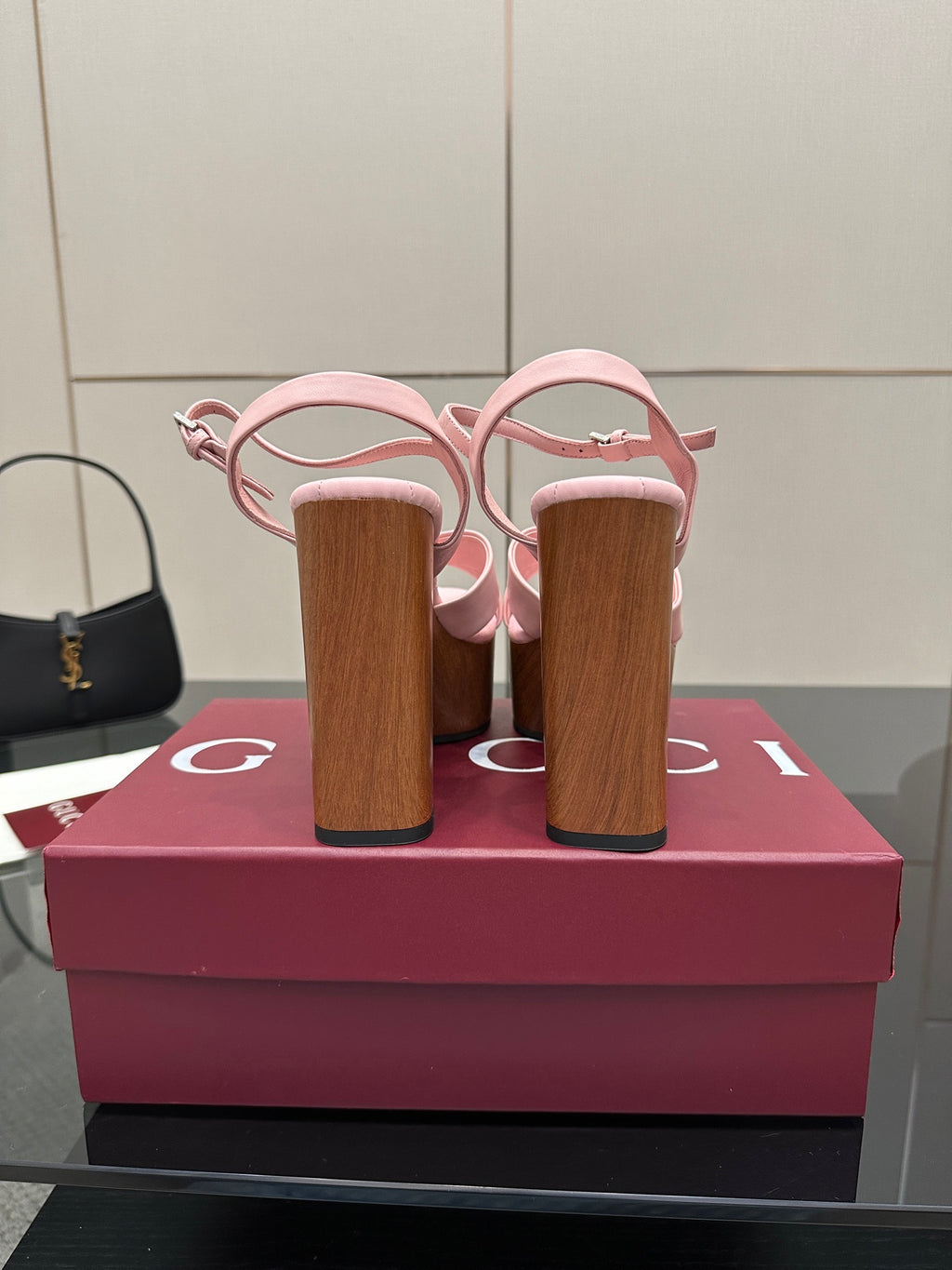 Pink platform sandals with wooden block heels from the back, showing heel counters