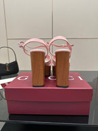 Pink platform sandals with wooden block heels from the back, showing heel counters