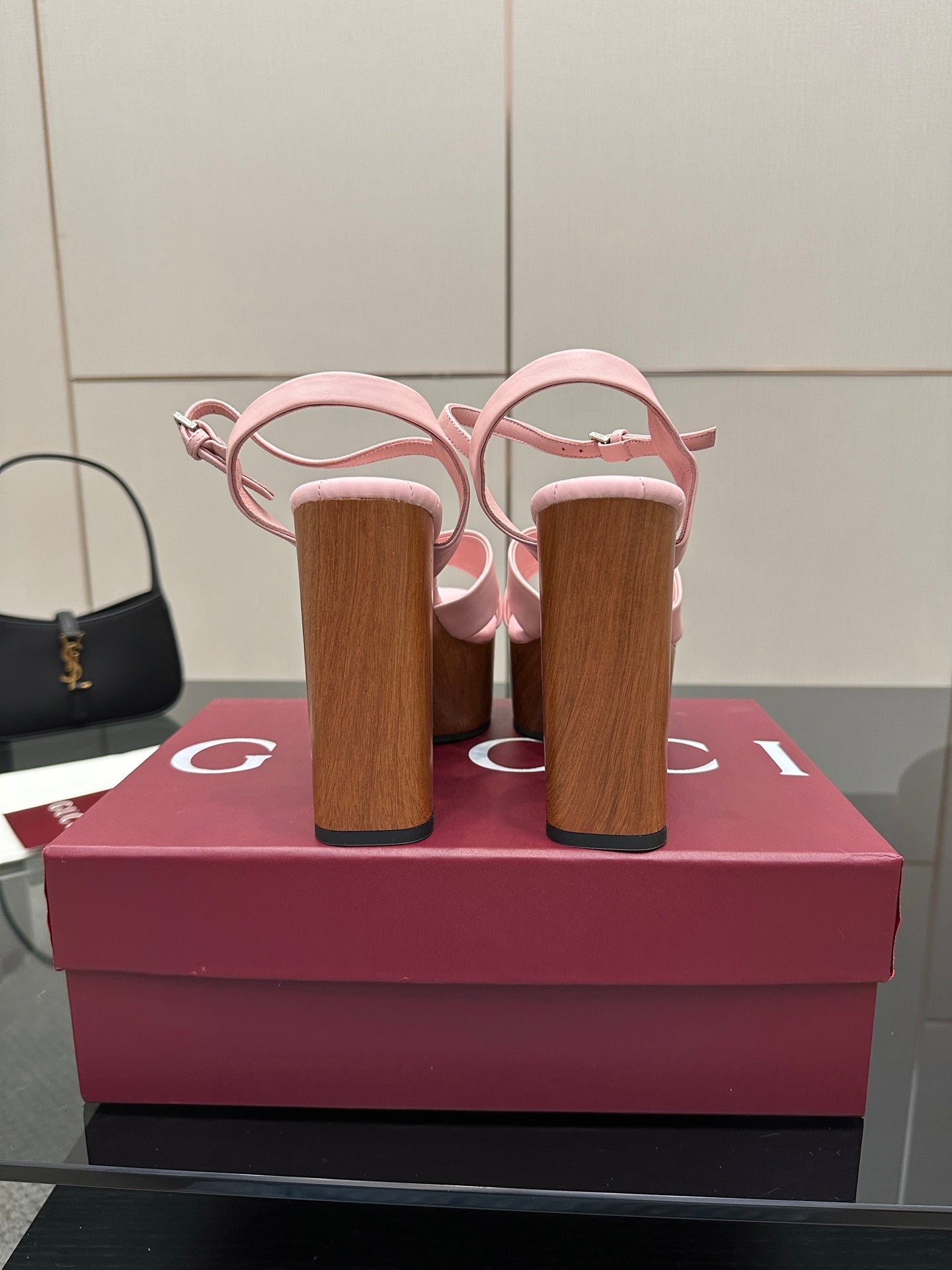 Pink platform sandals with wooden block heels from the back, showing heel counters