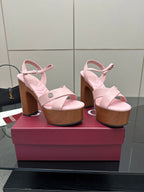 Pair of pink platform sandals with ankle straps and wooden block heels, side view