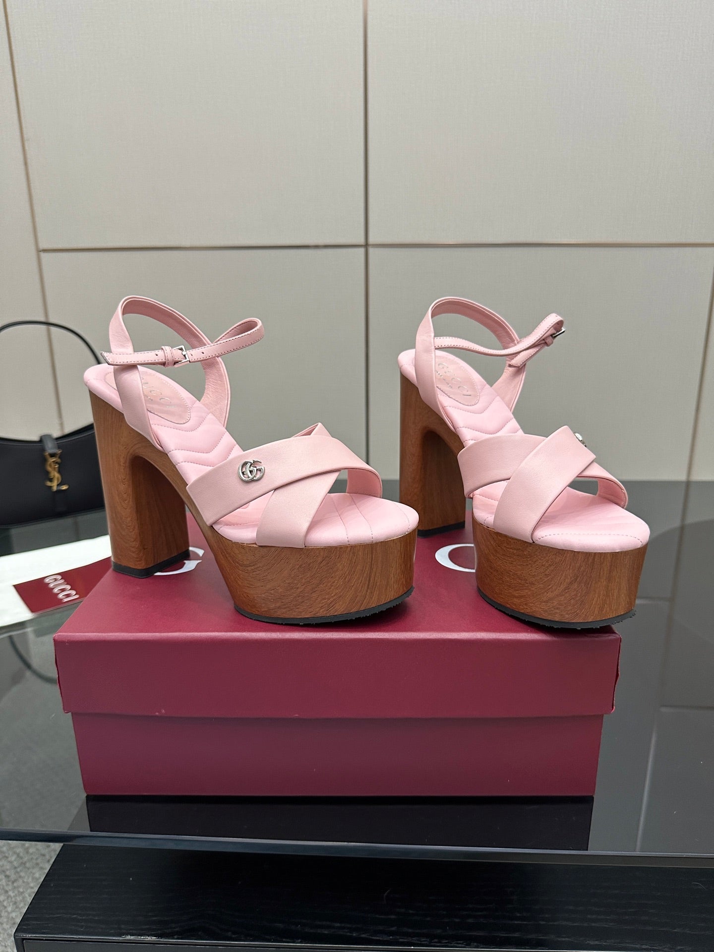 Pair of pink platform sandals with ankle straps and wooden block heels, side view