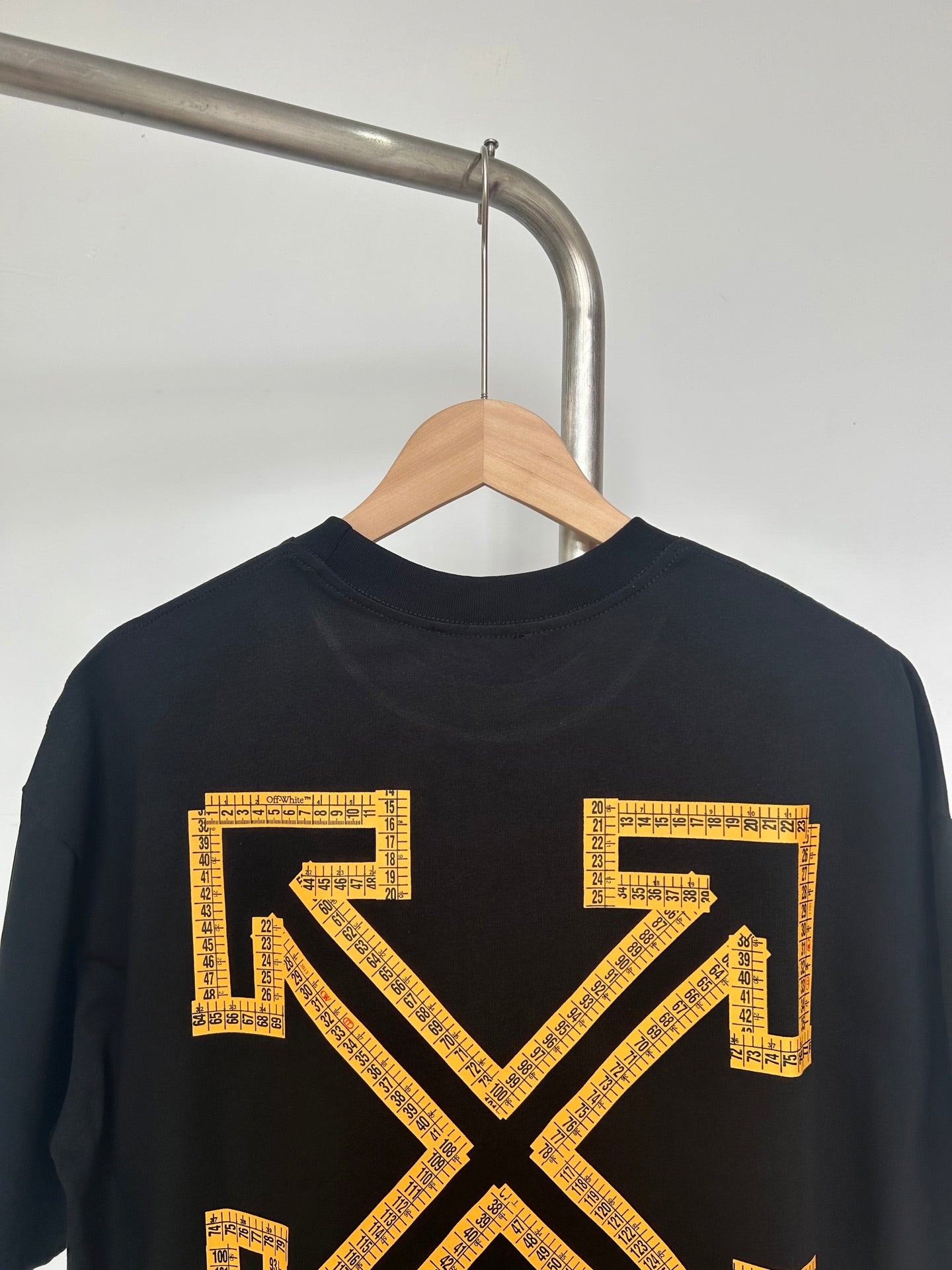 Dark T-shirt with large yellow Off-White™ arrow X graphic