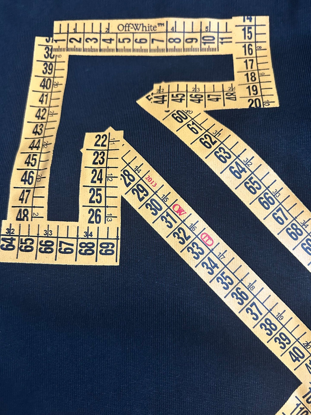 Off-White arrow and numbers graphic on dark T-shirt fabric