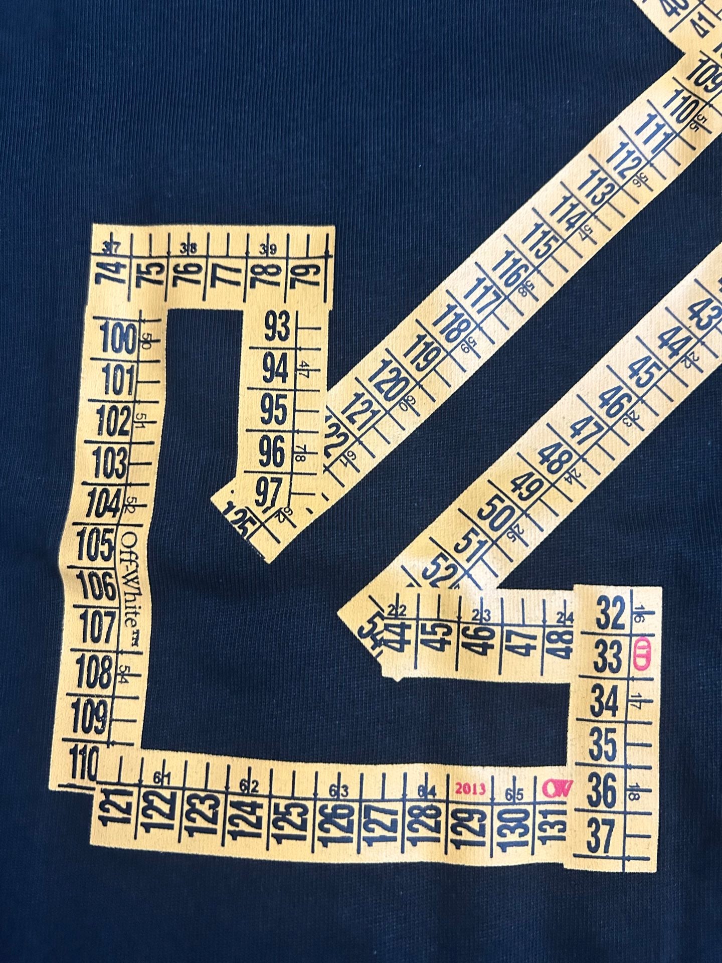 Off-White arrow graphic and numbers on dark T-shirt fabric