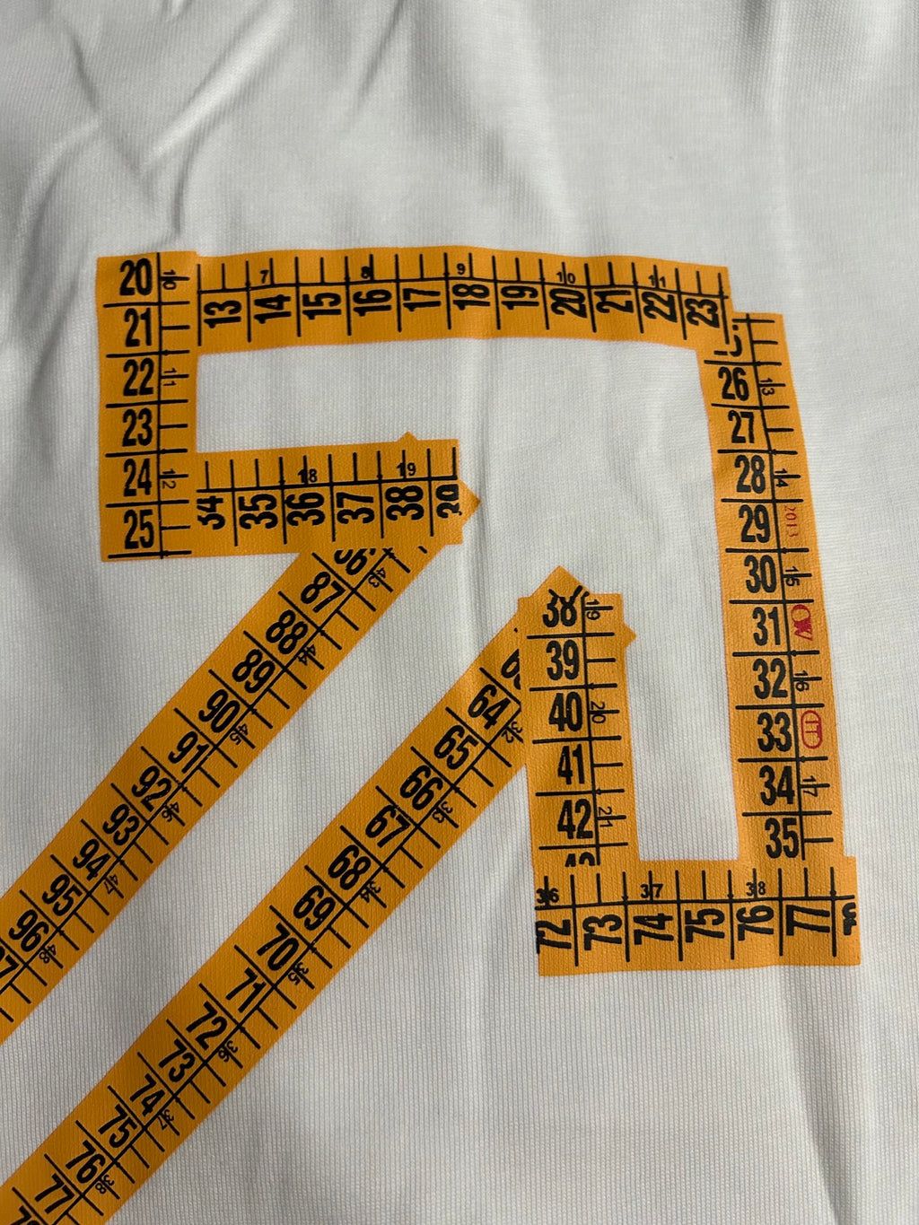 Off-White T-shirt close-up with orange ruler-lined arrow X graphic