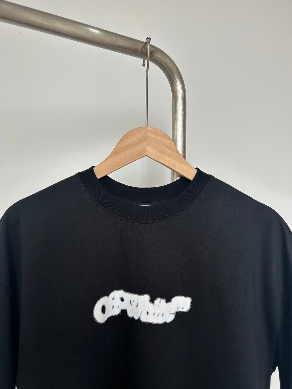 Black T-shirt with off-white logo graphic on chest, crew neckline