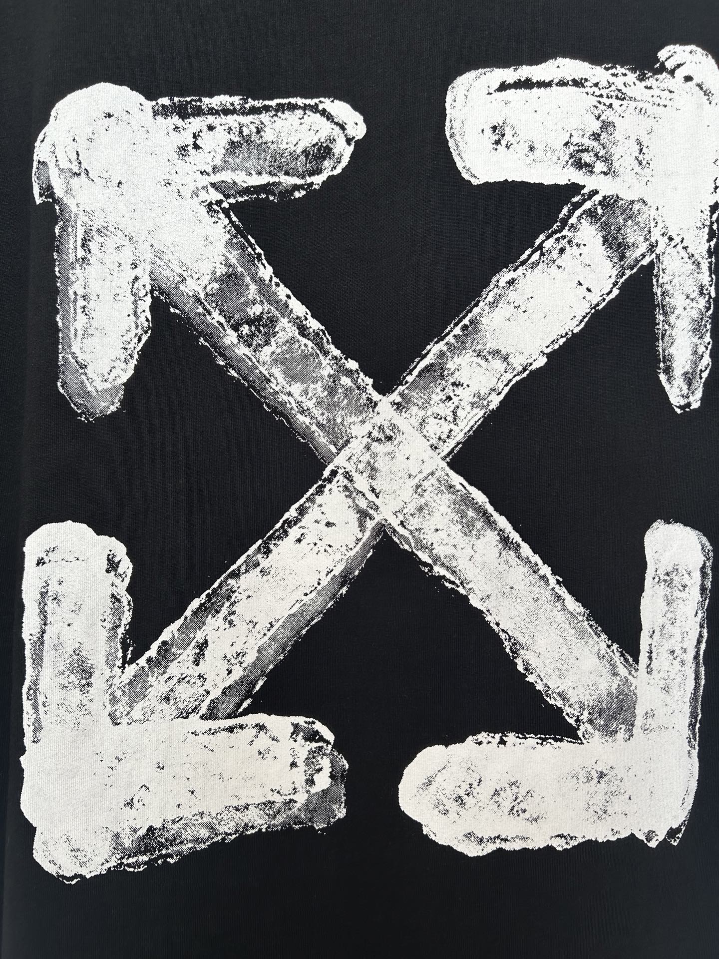 Black T-shirt close-up of off-white distressed X and arrows graphic