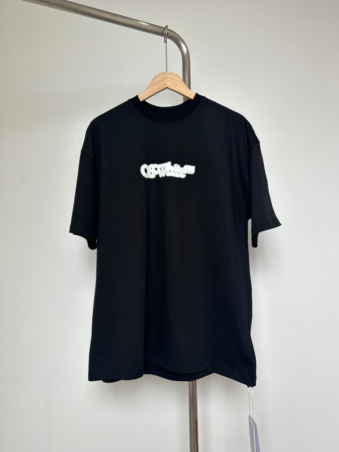 Black T-shirt with small off-white logo graphic on chest