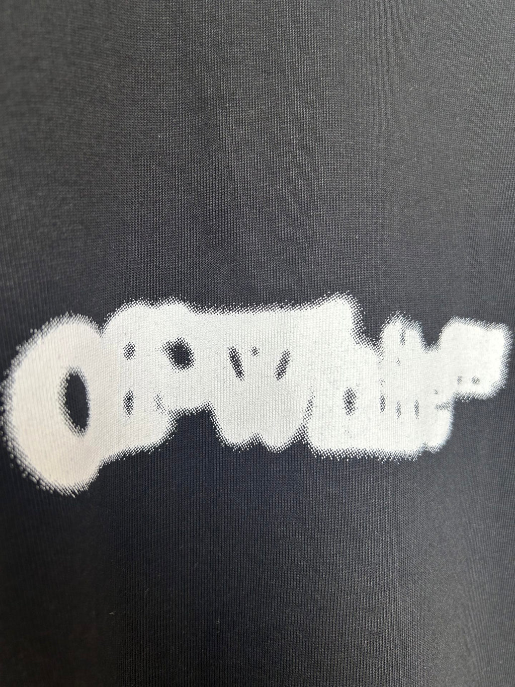 Black T-shirt fabric with off-white distressed logo detail