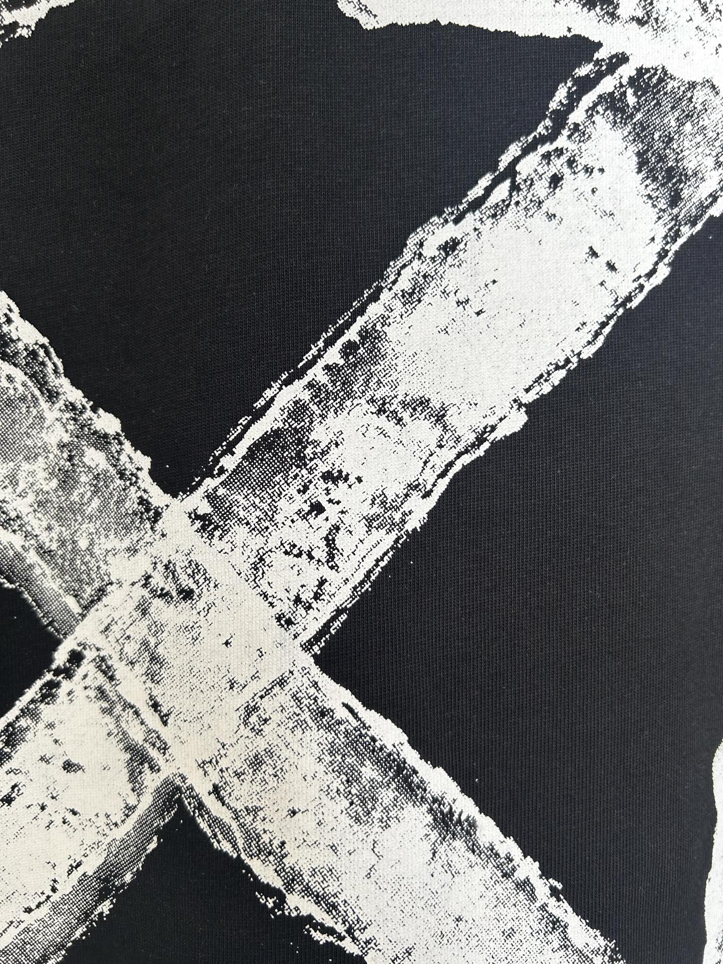 Black T-shirt close-up of off-white distressed X graphic detail