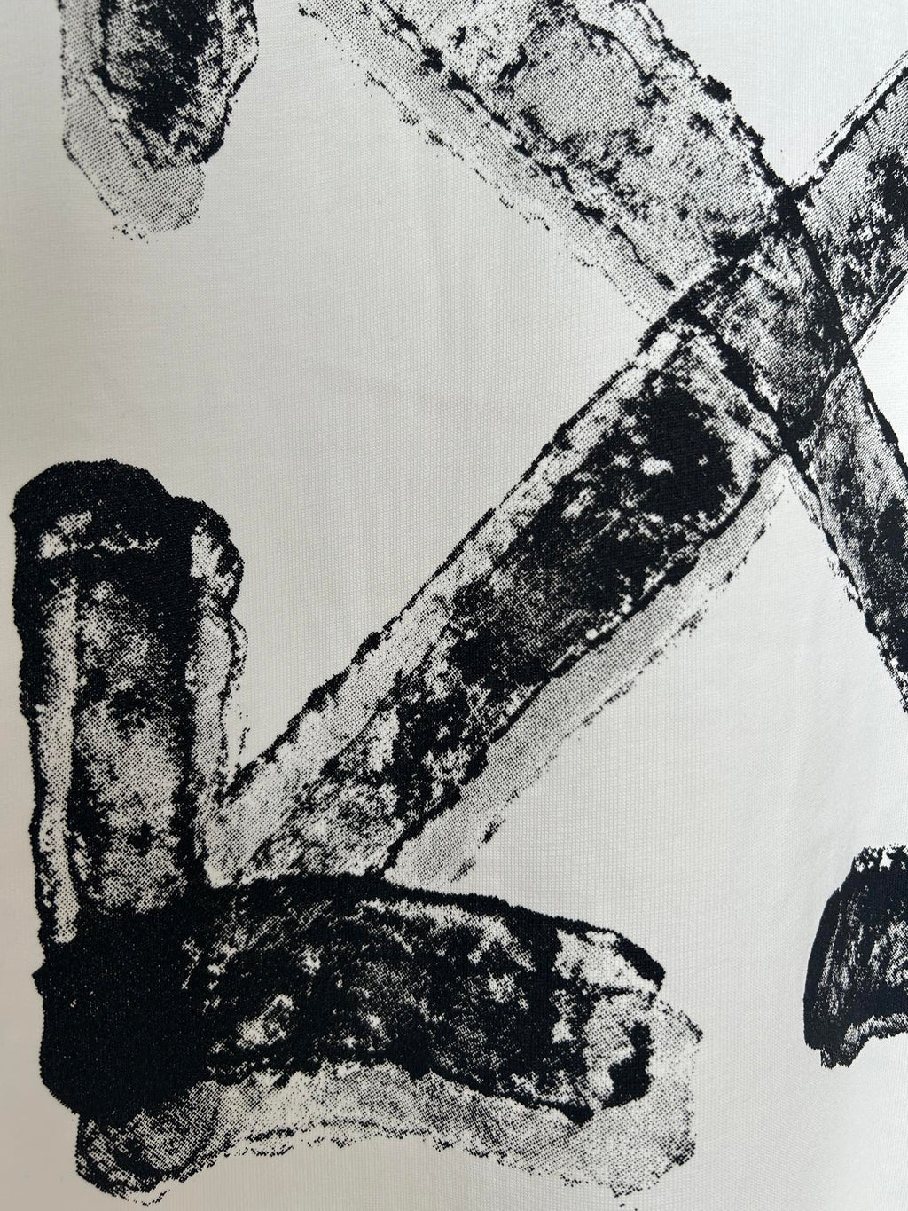 Off-white T-shirt close-up of black logo letter strokes